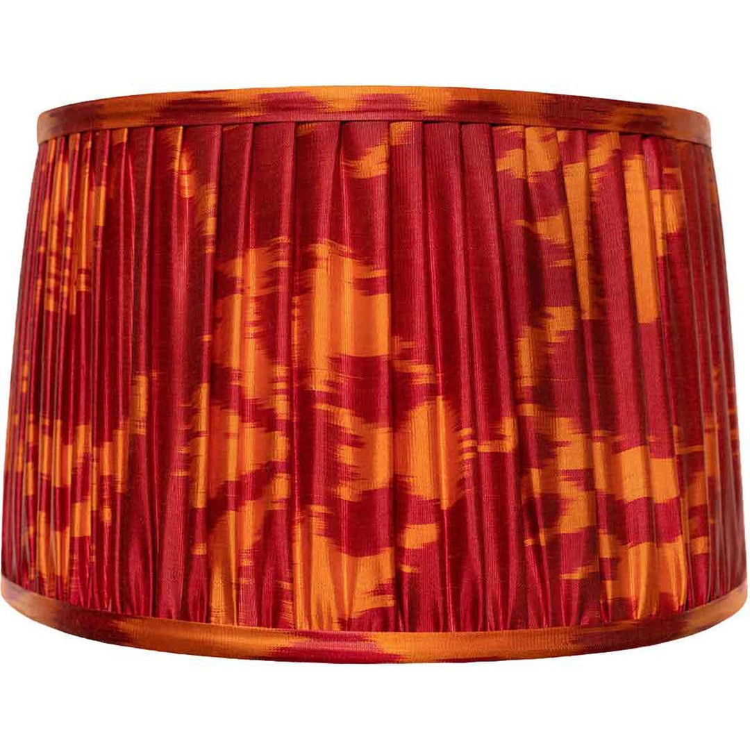 Front view of Mekhann's red and orange ikat silk lampshade, hand-pleated with a fiery pattern using sustainable dyes.