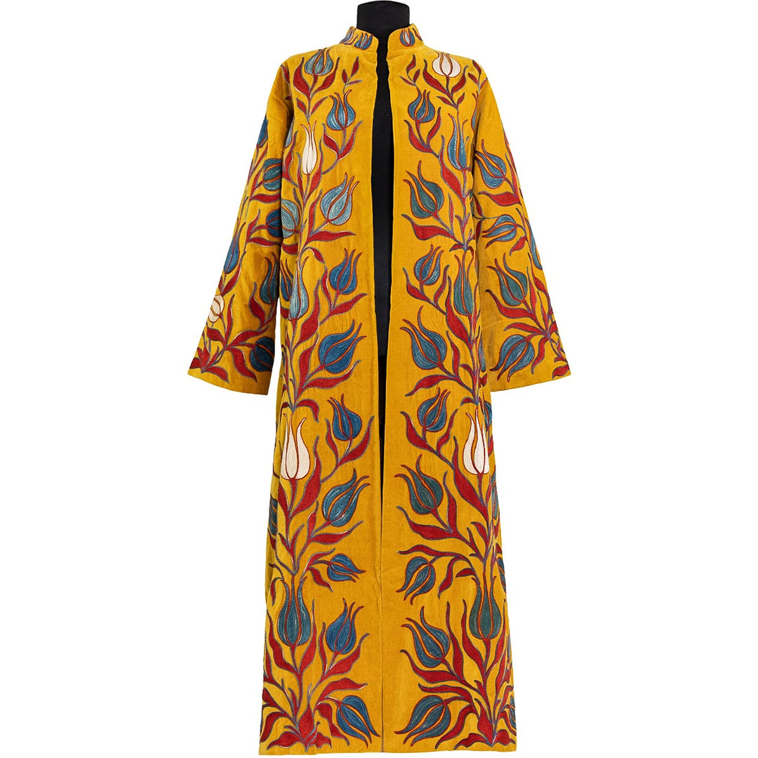 Front view of Mekhann's embroidered velvet tulips kaftan in saffron, with a blue and red hand embroidered tulips that saturate the surface of the kaftan.