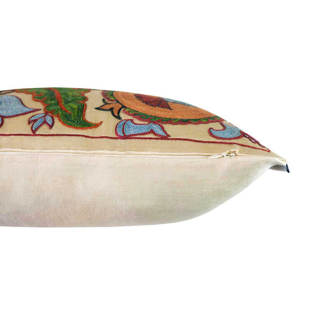 Side view of Mekhann's hand embroidered silk iznik cushion in cream. Revealing where the cream coloured silk used as the base for the iznik embroidered meets the light cream back face of the cushion.