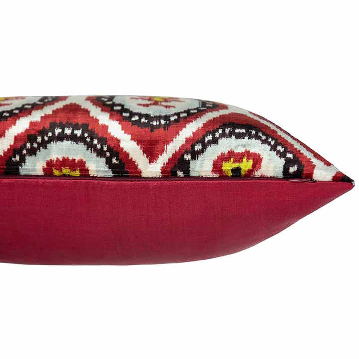 Side view of Mekhann's maroon pattern velvet cushion, showing where the maroon silk back meets the bright velvet front