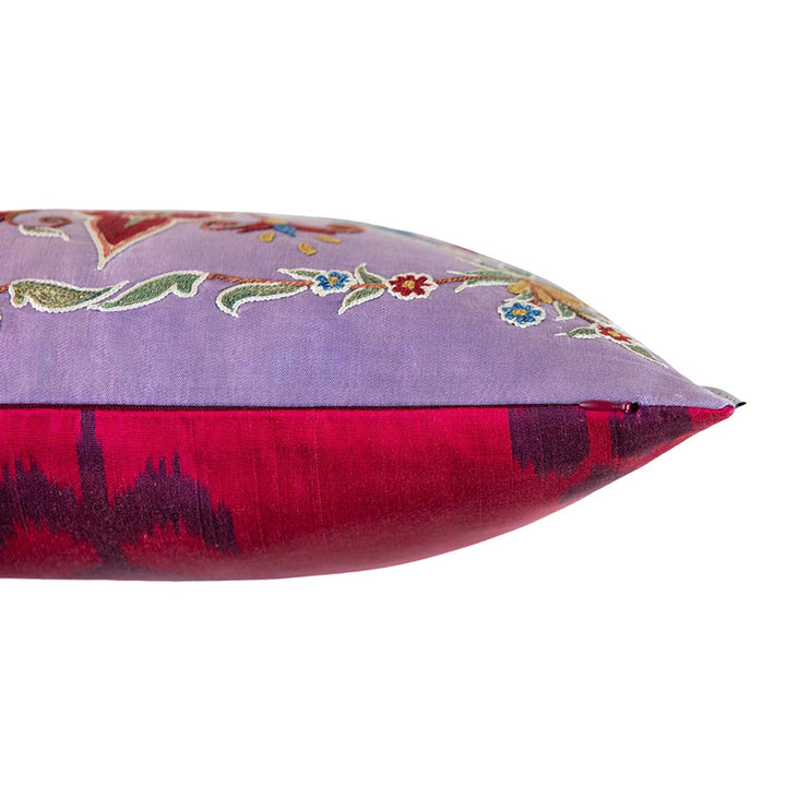 Side view of Mekhann's multicoloured abstract embroidered cushion, showing where the pink ikat lining meets the purple silk front lining. 