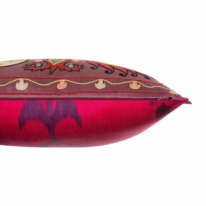 Side view of Mekhann's multicoloured lotus embroidered cushion, showcasing where the ikat back face of the cushion meets the dark silk front face of the cushion.