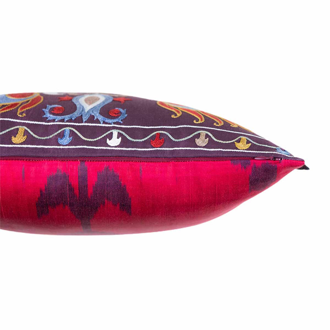 Side view of Mekhann's multicoloured lotus embroidered cushion, revealing where the iakt back face of the cushion meets the dark silk front face of the cushion.