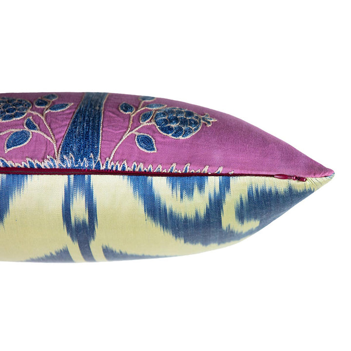 Side view of Mekhann's  multicoloured pomegranate embroidered cushion, showing the side of the cushion and where the ikat blue and cream lining meets the purple silk front lining.