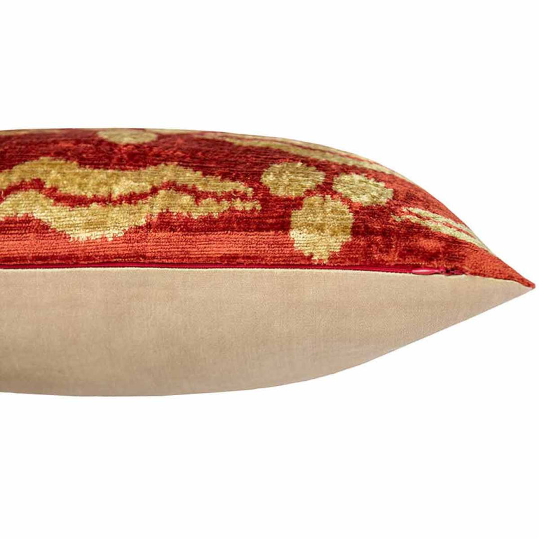 Side view of Mekhann's orange pattern velvet cushion, showing where the orange velvet front meets the plain cream silk back face.