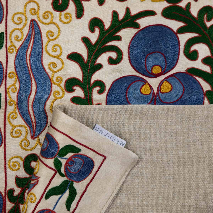 Folded view of Mekhann's cream cintamani runner, with the back lining in full display in a beige colour with the Mekhann label on display.