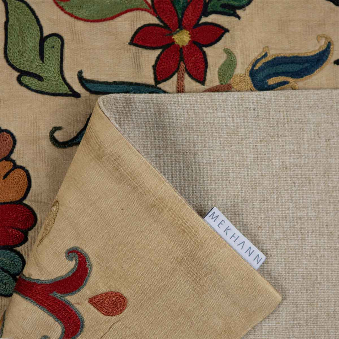 Folded view of Mekhann's silk tulip petite throw, showcasing the delicate patterns, the lining of the back of the throw with the Mekhann label.