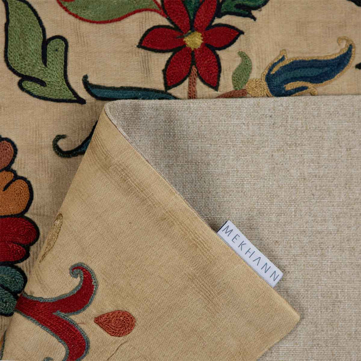 Folded view of Mekhann's silk tulip petite throw, showcasing the delicate patterns, the lining of the back of the throw with the Mekhann label.