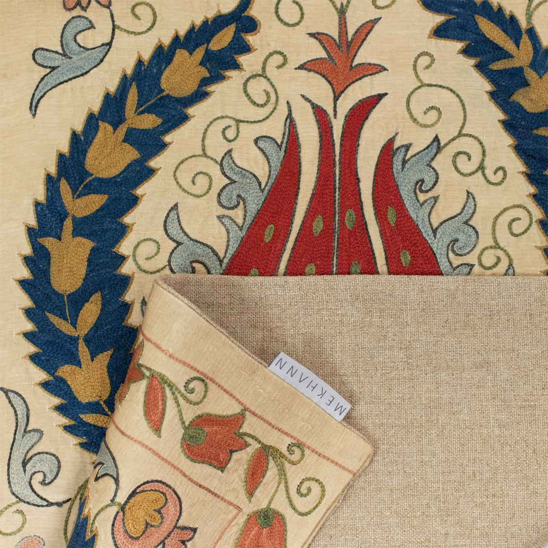 Folded view of Mekhann's cream tulips runner, showing how the beige lining complements the front of the runner and also showing the Mekhann label attached to the runner.