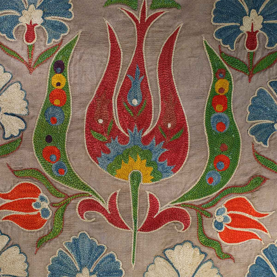 Close up view of Mekhann's grey tulip runner, showing up close the detail of the tulip embroidery in bright red against the grey silk background.