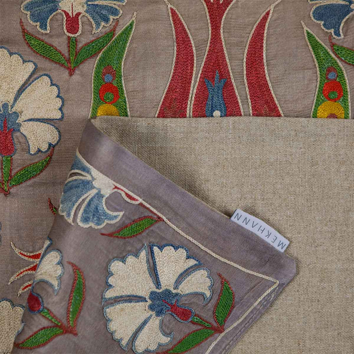 Folded view of Mekhann's grey tulip runner, showing the beige back lining of the runner seen with the Mekhann label.