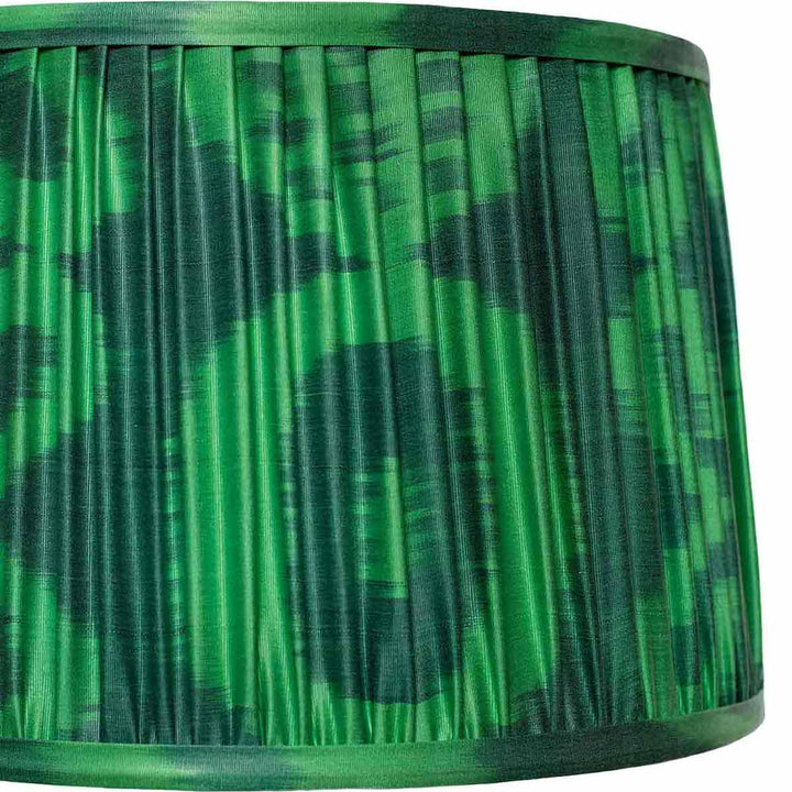 Close-up of Mekhann's silk lampshade with a green ikat pattern, showcasing the intricate dye work and quality craftsmanship.