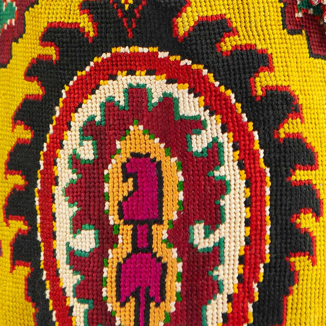 Close up view of Mekhann's yellow arabesque embroidered bucket bag, displaying the detail in the cross stitching method used. 