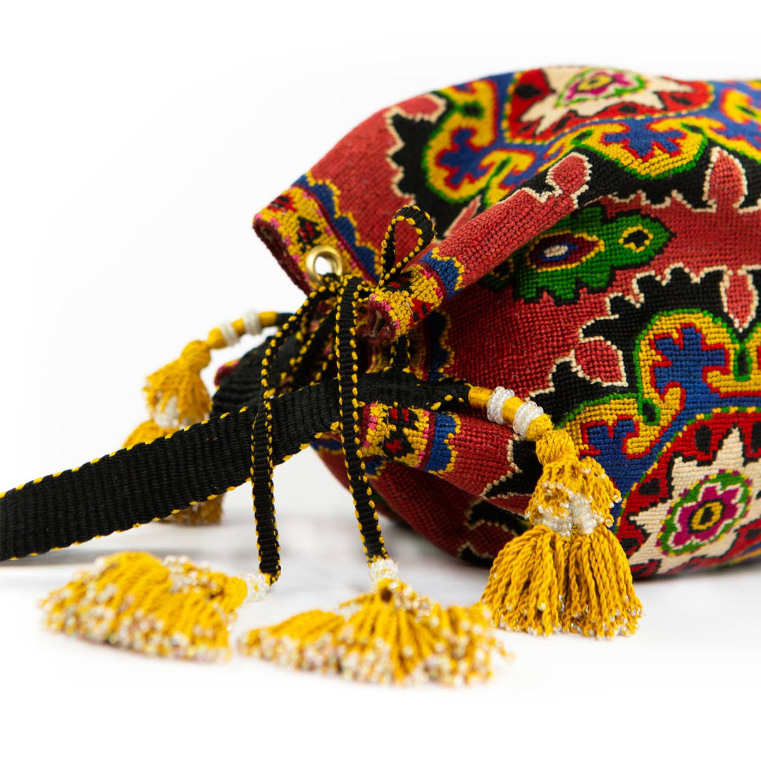 Top view of Mekhann's arabesque clementine bucket bag, showing the elaborate embroidery that wraps around and the sturdy drawstring.