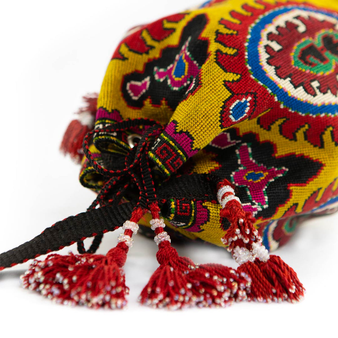 Top view of Mekhann's yellow arabesque bucket bag, showing the elaborate embroidery that wraps around and the sturdy drawstring.