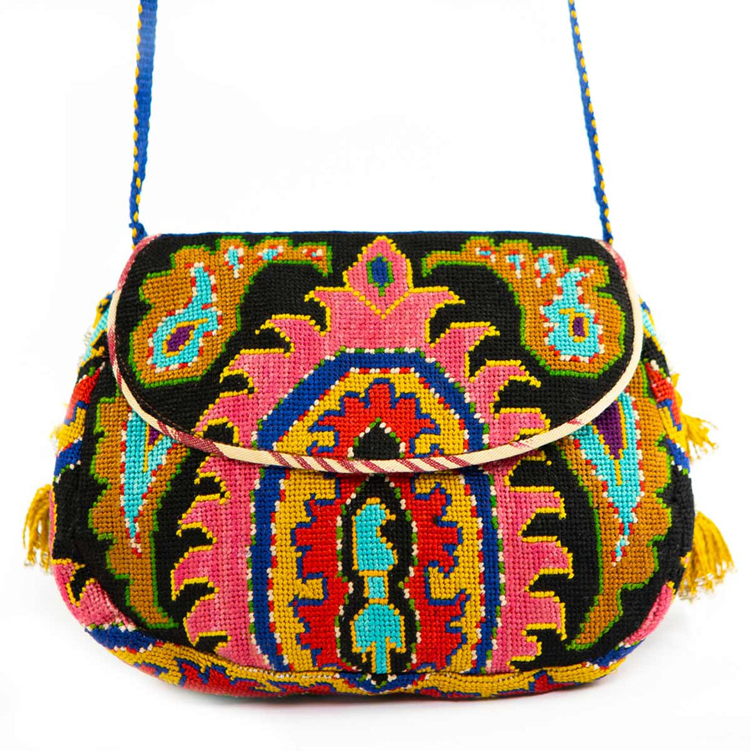Front view of Mekhann's black and multicoloured arabesque embroidered cross-body bag, a bold display of pinks, blues and earth tones on a black base.