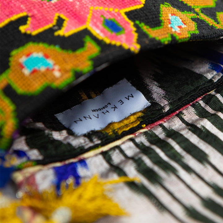 Inside view of Mekhann's black and multicoloured arabesque embroidered cross-body bag, revealing a ikat lining for beauty and durability.