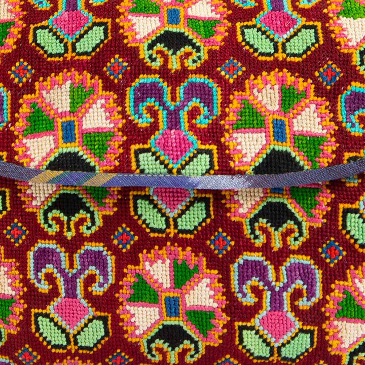 Close up view of Mekhann's arabesque embroidered cross-body bag, emphasizing the vibrant embroidery and exquisite craftsmanship.