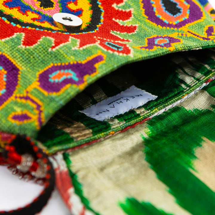 Inside view of Mekhann's green arabesque embroidered cross-body bag, displaying a beautiful green ikat interior.