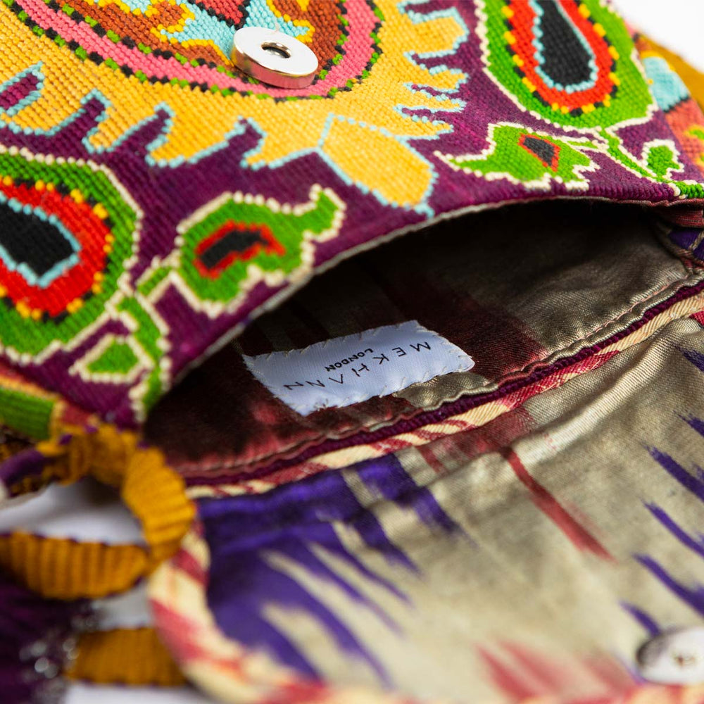 Inside view of Mekhann's yellow, purple and multicoloured arabesque embroidered cross-body bag, showing a ikat lining for style and durability.