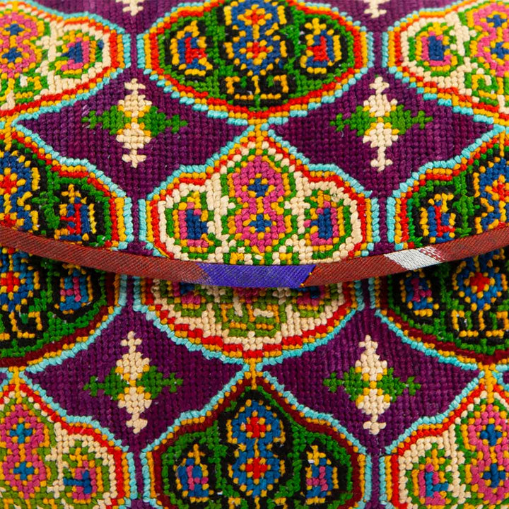 Close up view of Mekhann's royal purple arabesque embroidered cross-body bag, displaying all the design details and stitching on the bags surface.