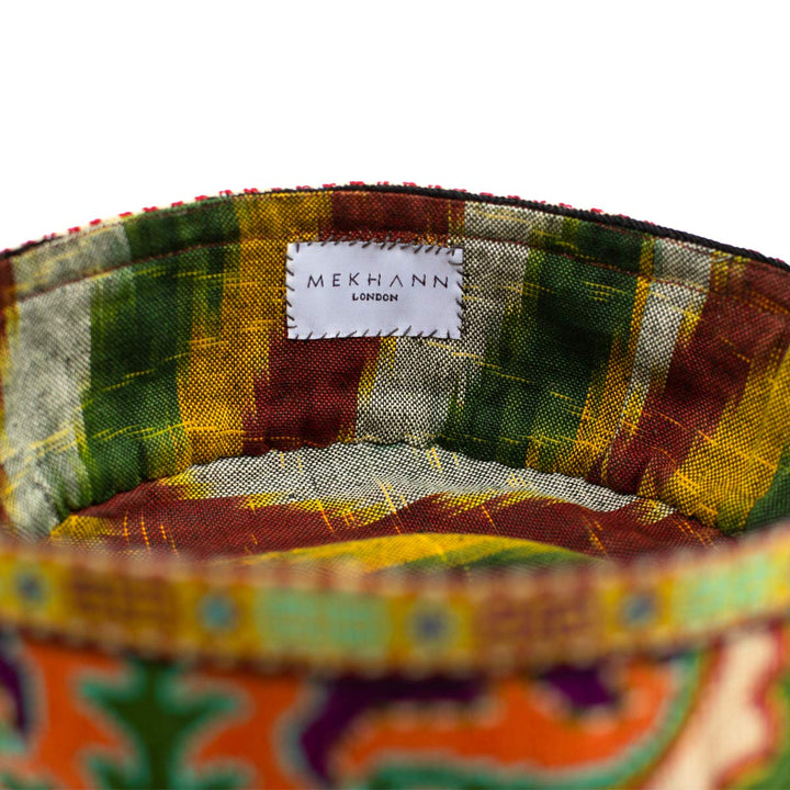 Inside view of Mekhann's green arabesque skull cap, showcasing a unique strip like ikat lining in green, yellow and brown.