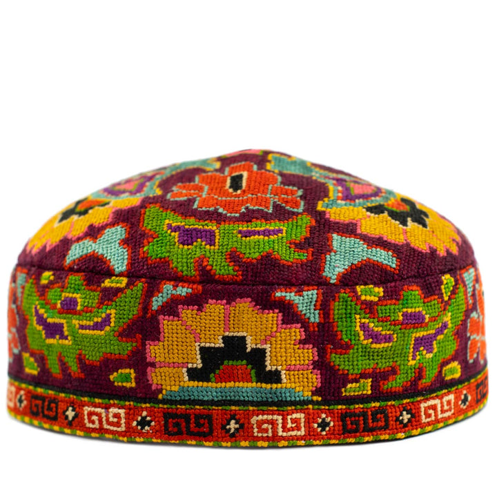 Front view of Mekhann's maroon arabesque skull cap, Showcasing the collection of bright hand embroidered patterns on a based of maroon.