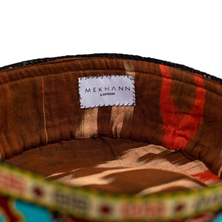 Inside view of Mekhann's multicoloured arabesque skull cap, revealing the brown and red ikat lining used for both style and comfort when wearing the skull cap.