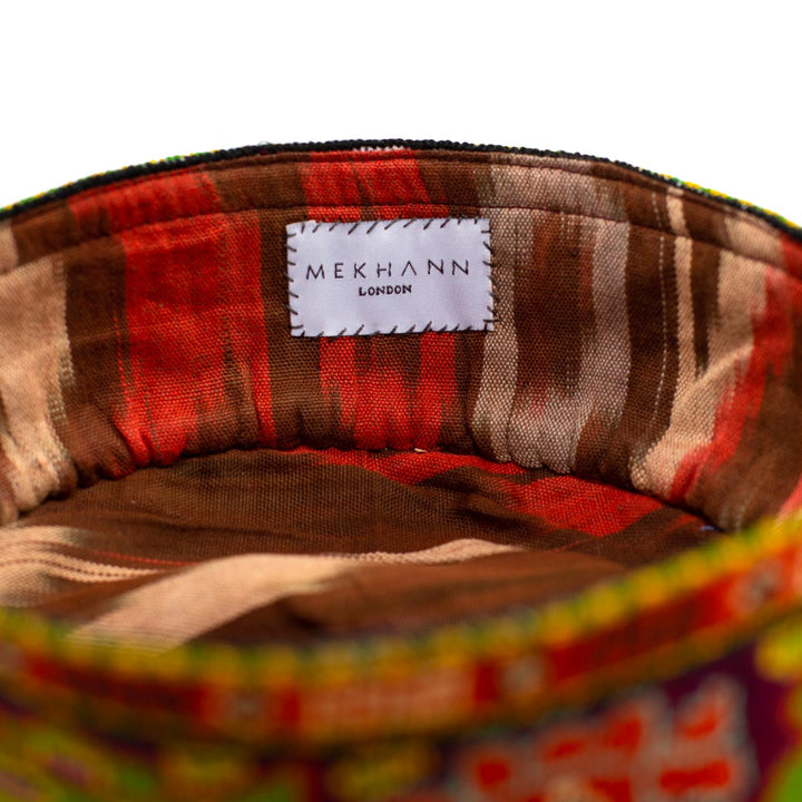 Inside view of Mekhann's maroon arabesque skull cap, Revealing a brown, red and cream ikat pattern used for the wears comfort.