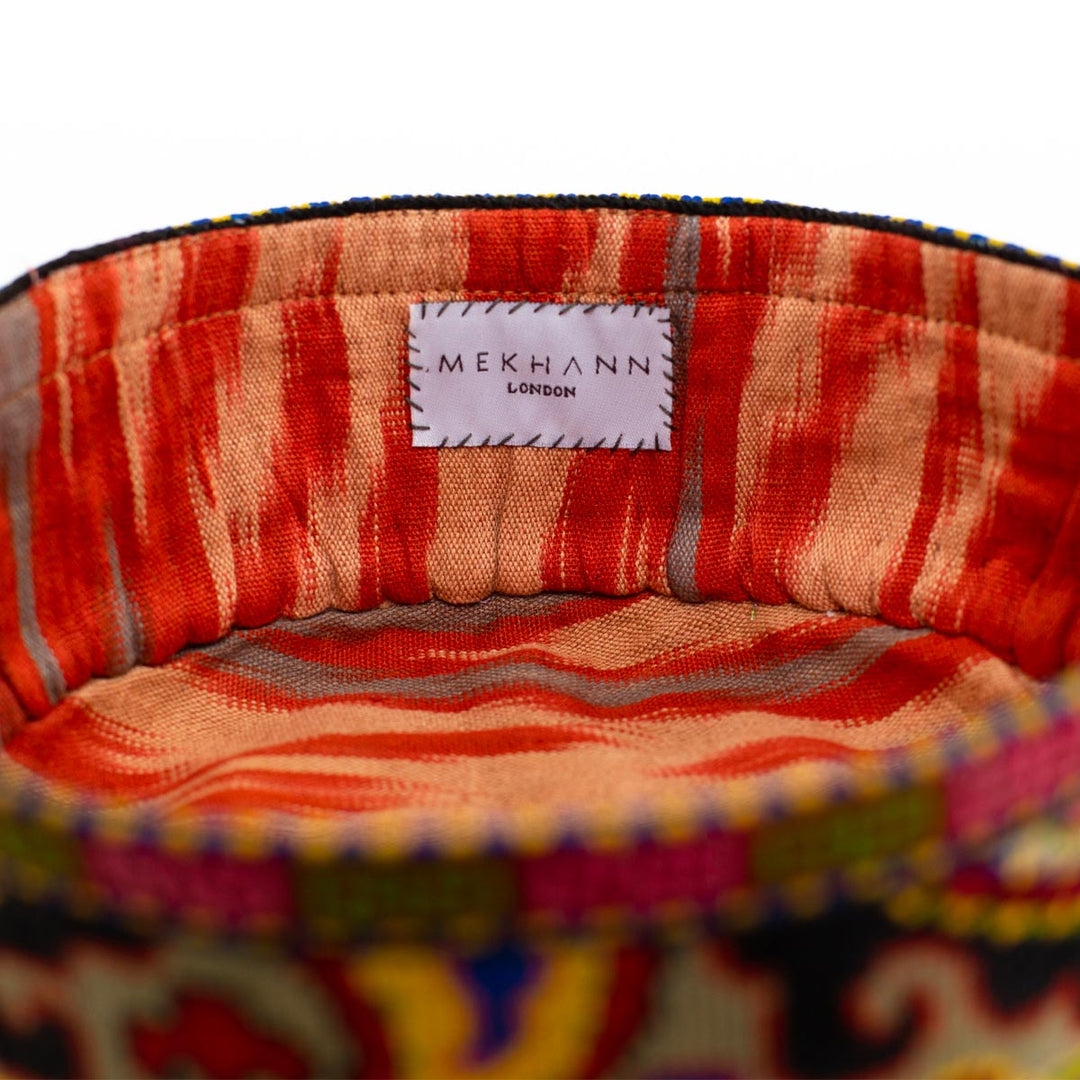 Inside view of Mekhann's arabesque multicoloured skull cap, revealing a red toned ikat lining for durability and comfort.
