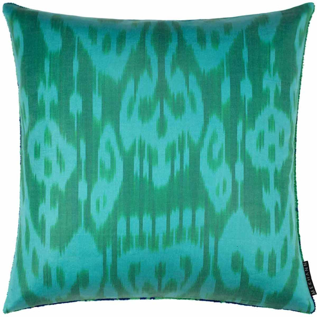Back view of Mekhann's green tulips velvet cushion, revealing a blue ikat fabric back face of the cushion.