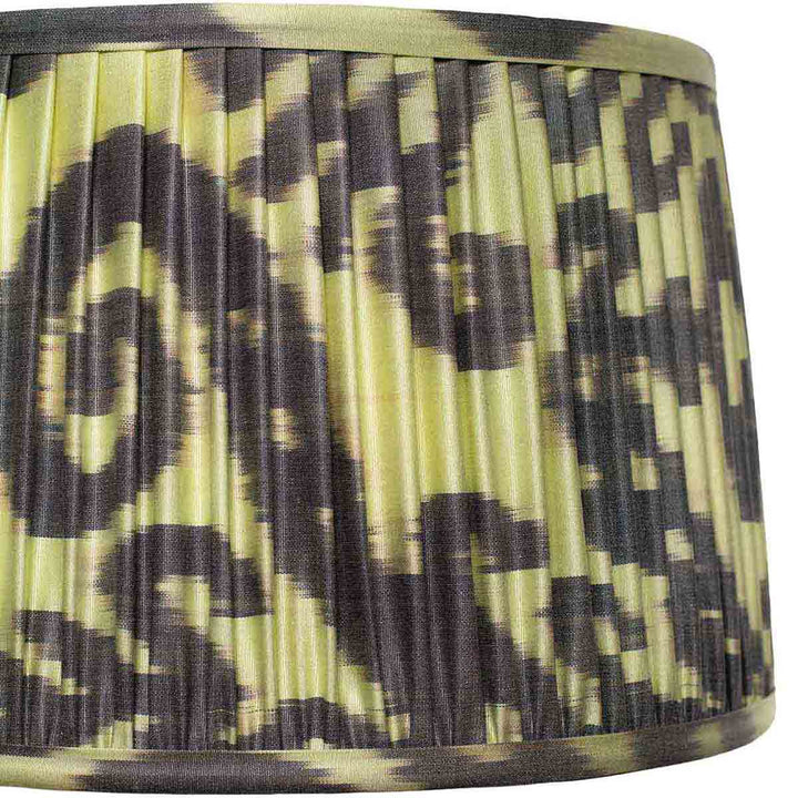 Close-up of the bold ikat design on Mekhann's lampshade, featuring sharp black and green contrasts and meticulous pleating.