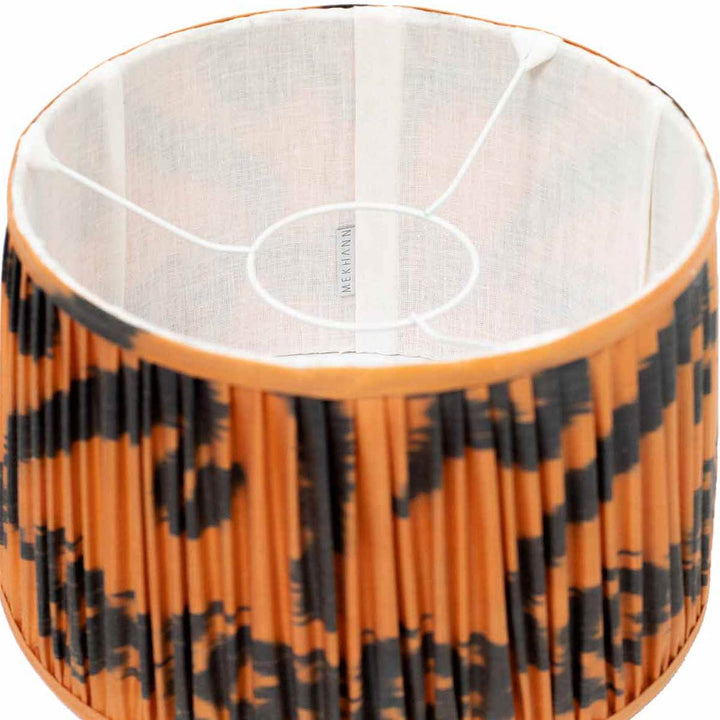 Interior shot of Mekhann's silk lampshade, featuring a striking black and orange ikat design for a contemporary space.