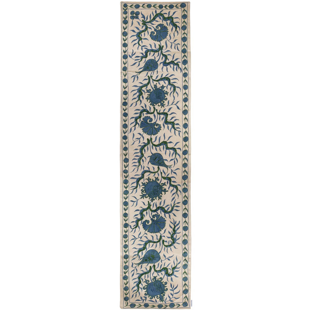 Front view of Mekhann's cream ottoman vines runner, featuring a blue Ottoman vines pattern that stretches the length of the runner all hand embroidered on a base of cream coloured silk.