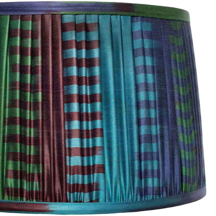 Close-up of Mekhann's ikat lampshade, with its intricate blue and green pattern and handcrafted pleating detail.