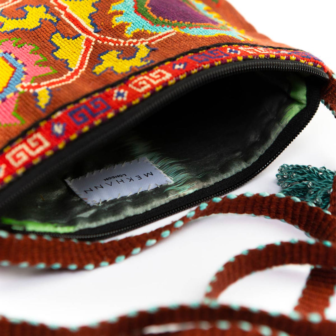 Inside view of Mekhann's brown and multicoloured botanical embroidered cross-body, showcasing the durable ikat fabric interior.