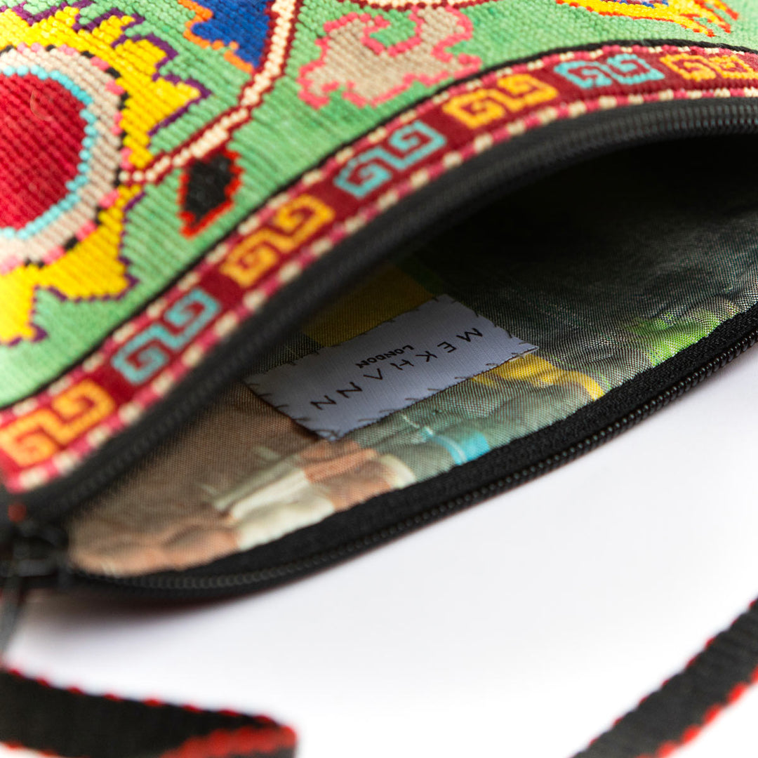 Inside view of Mekhann's mint botanical embroidered cross-body bag, showing the size and durability of the inside of the bag.