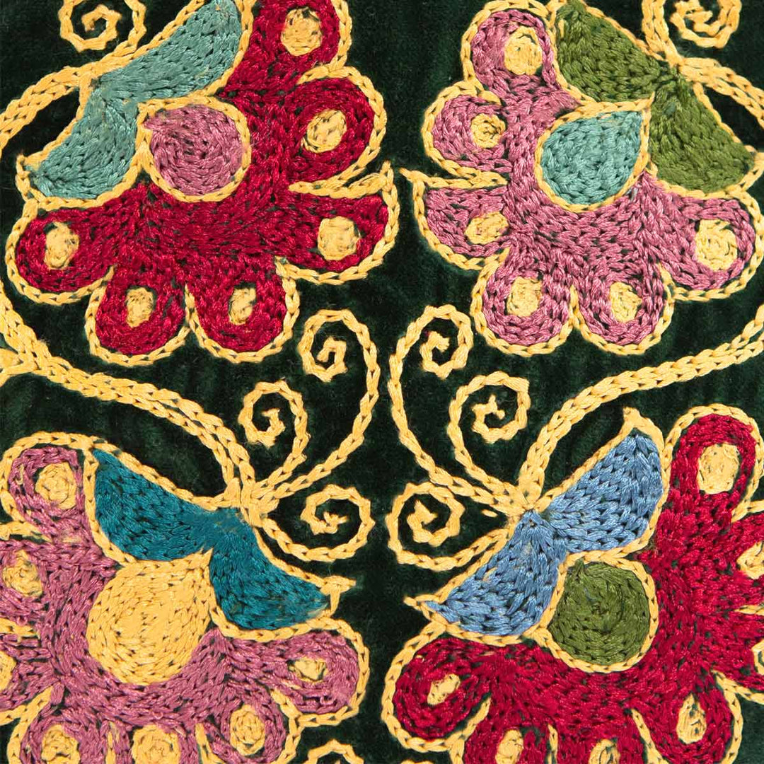 Close up view of Mekhann's botanical green velvet pouch, showing the embroidered flowers up close to see the attention to detail of the craftsmanship.