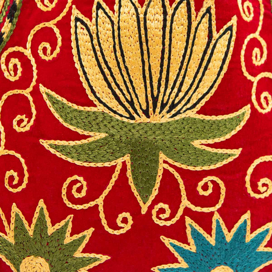 Close up view of Mekhann's botanical light maroon velvet pouch, bringing you closer to the cross stitch technique used on this pouch.