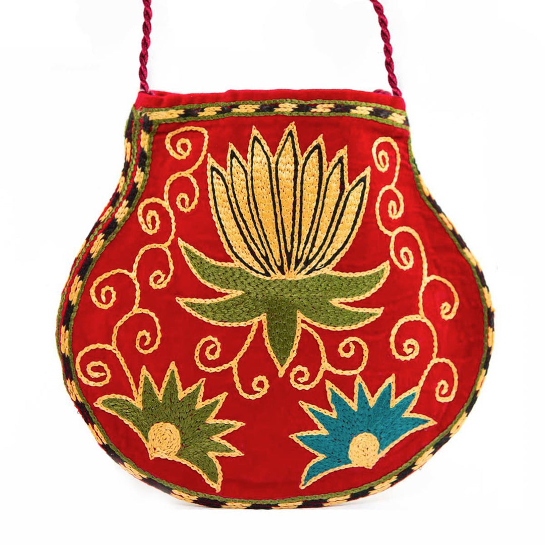 Front view of Mekhann's botanical light maroon velvet pouch, showcasing three bold flowers in blue, green, and yellow.