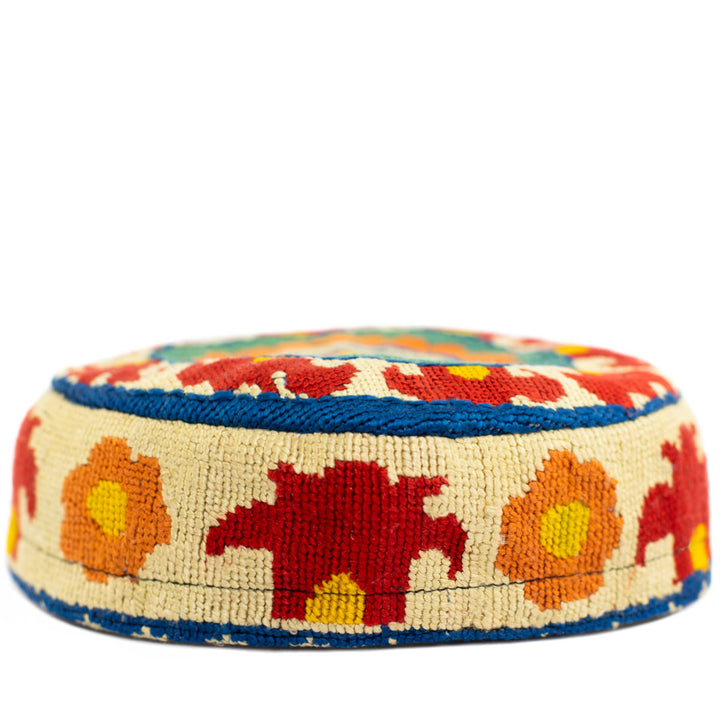 Front view of Mekhann's botanical skull cap, a captivating display of hand embroidered patterns in red, orange, blue and yellow.