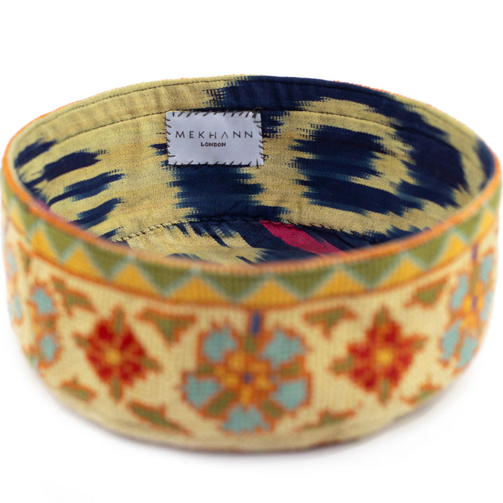Full frame view of Mekhann's botanical cream skull cap, showing how the exterior colour palette contrasts with the ikat lining.