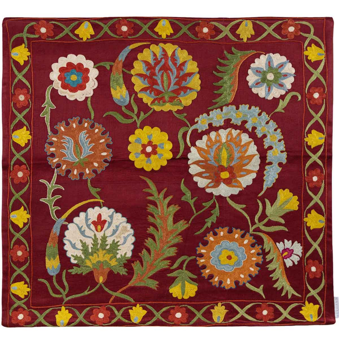 Front view of Mekhann's maroon botanical  petite throw, displaying intricate colourful embroidery in a classic botanical pattern, displayed in full view, all hand embroidered on a base of maroon coloured silk. 