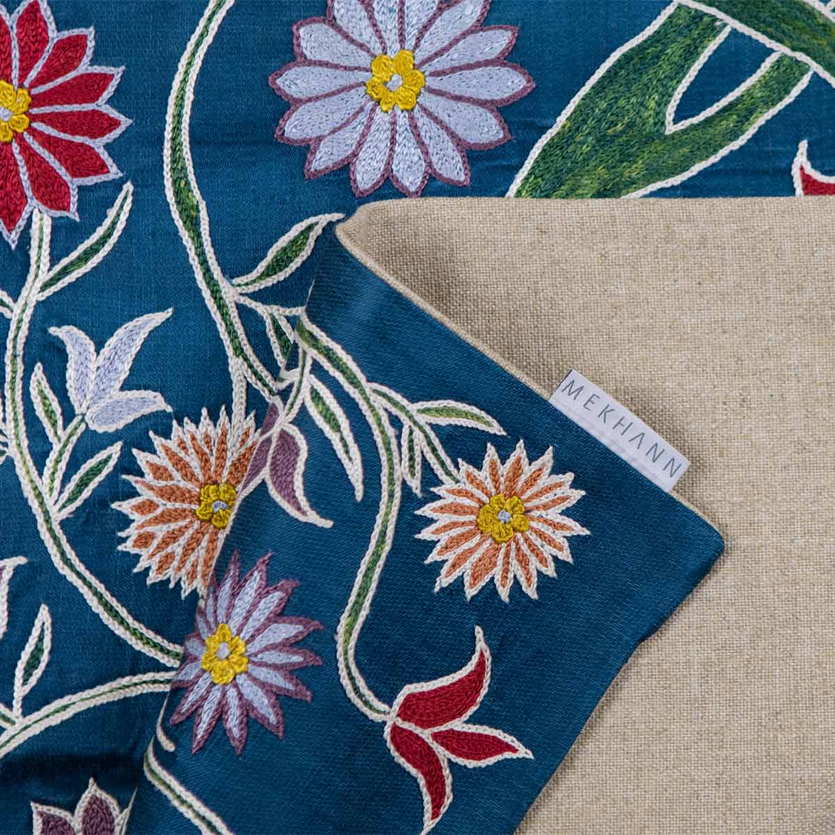 Folded view of Mekhann's navy botanical runner runner, displaying the back lining of the runner featuring the Mekhann label.