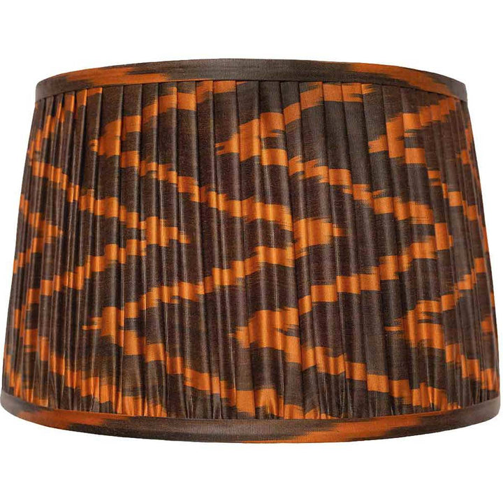Front view of Mekhann's brown and orange ikat silk lampshade, hand-pleated with earthy tones using sustainable dyes.
