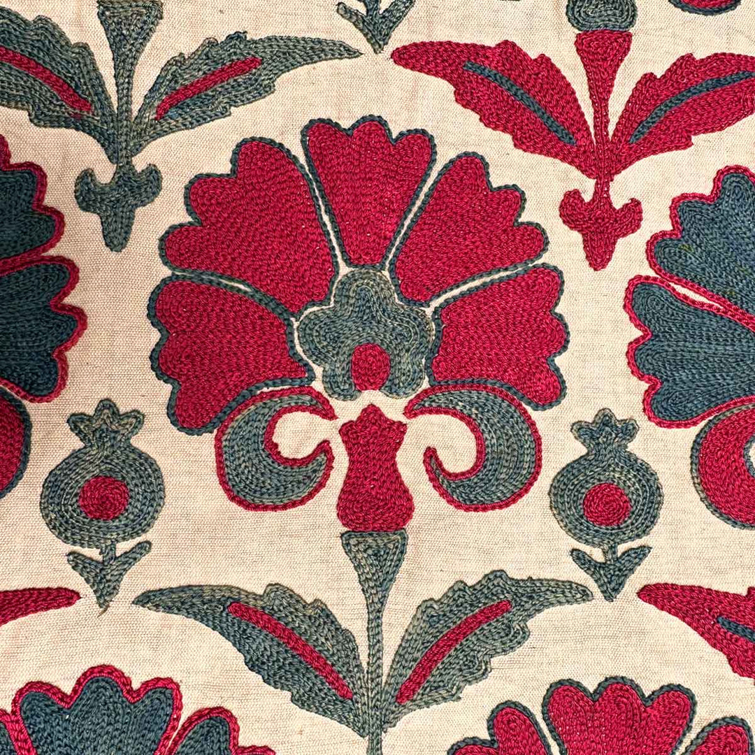 Detail view of Mekhann's carnations runner in pink and teal, showing the detailed embroidered patterns used to create the pink and teal carnations patterns on the cream silk background.