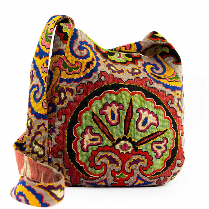 Front view with a low strap of Mekhann's multicoloured carnations embroidered shoulder bag, showcasing vibrant, detailed patterns and a stylish strap
