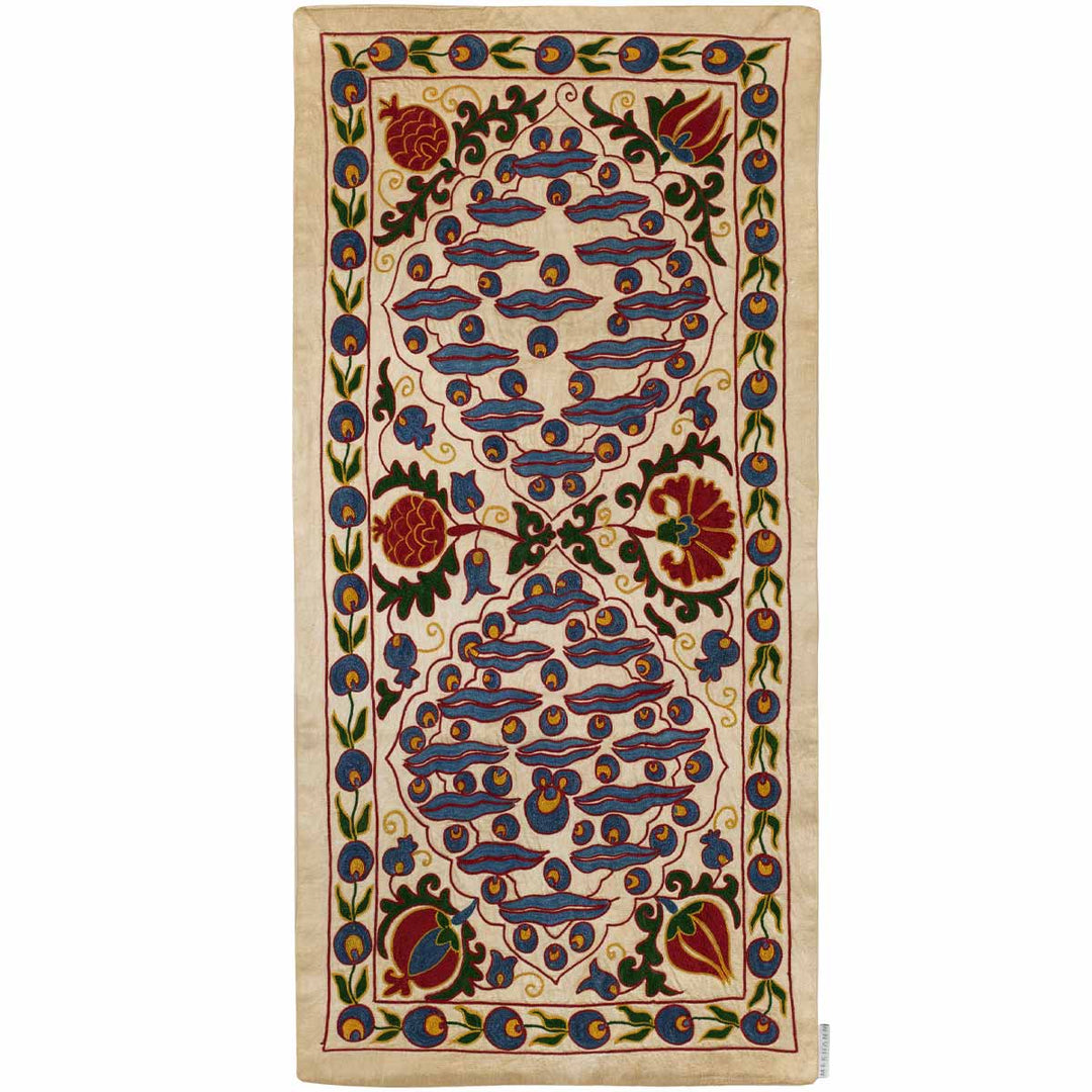 Front view of Mekhann's cream cintamani runner, with a full display of traditional hand embroidered cintamani patterns with a multitude of patterns in colours blue, red, and green set against a base of cream coloured silk.