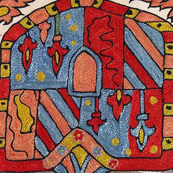 Close up view of Mekhann's abstract embroidered cushion, a close up of the crest details all hand embroidered using silk yarns in hues of blue, red and yellow.