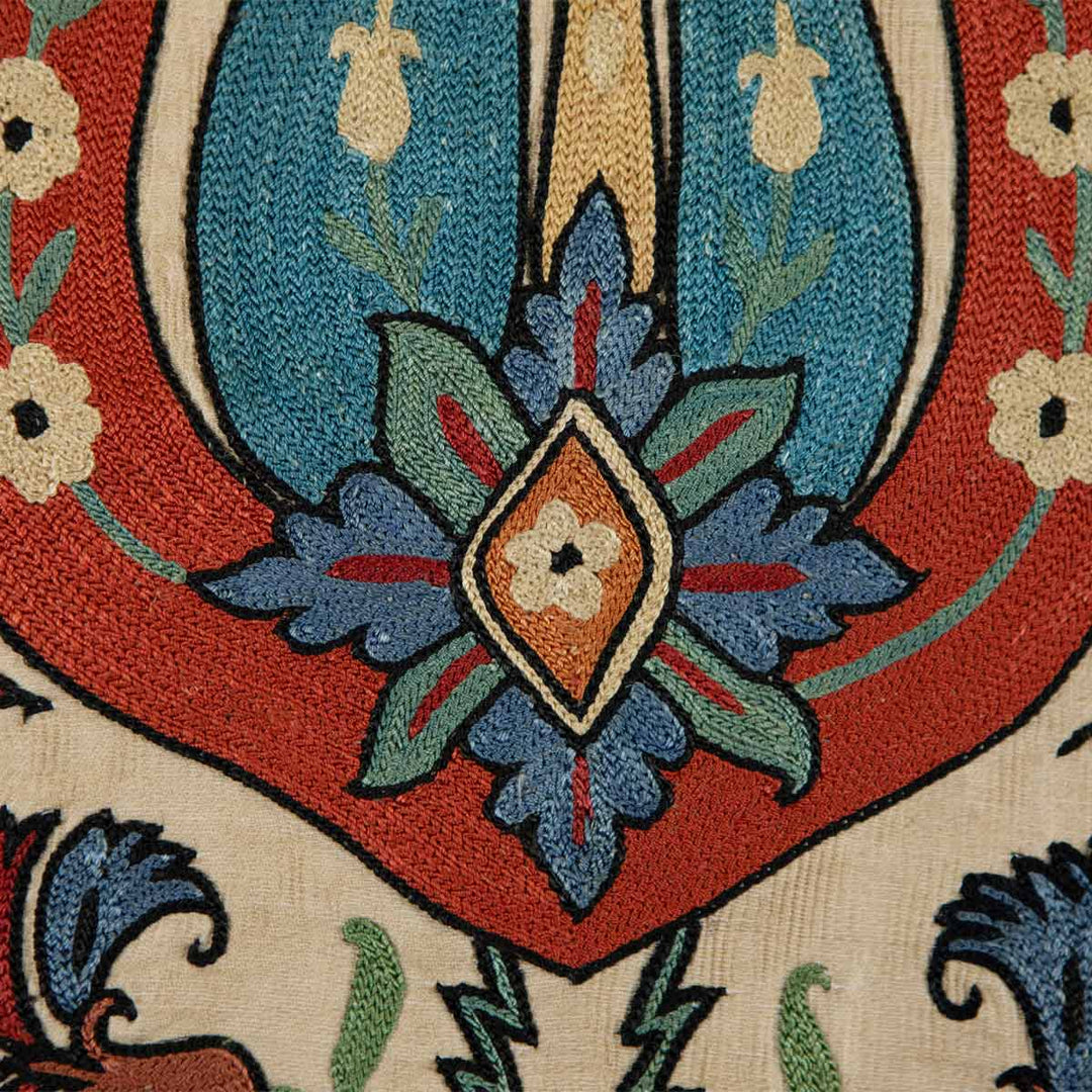 Detailed embroidery of a tulip on Mekhann's silk throw, showcasing the fine craftsmanship and vibrant color scheme on a high-quality fabric.